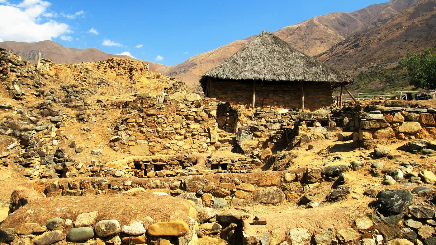 Sitio arqueológico de Kotosh; bajo el techo de paja se protege el Templo de las Manos Cruzadas