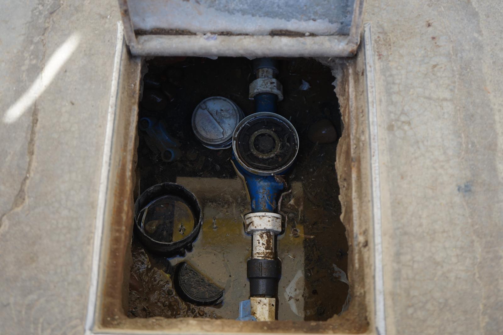 Medidor de agua sumergido en el barro de su caja de registro